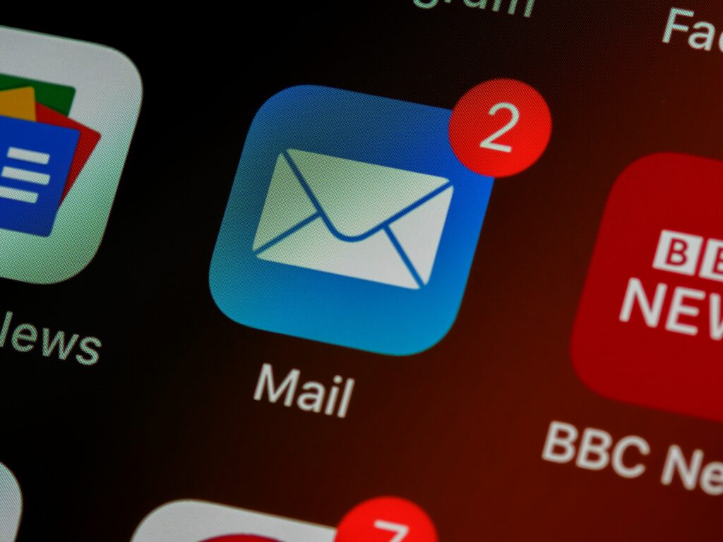 Newsletter_Logo_unsplash_brett-jordan-LPZy4da9aRo Ein E-Mail-Symbol neben anderen App-Symbolen auf einem Bildschirm. Zwei neue Nachrichten - vielleicht ja auch ein Newsletter.